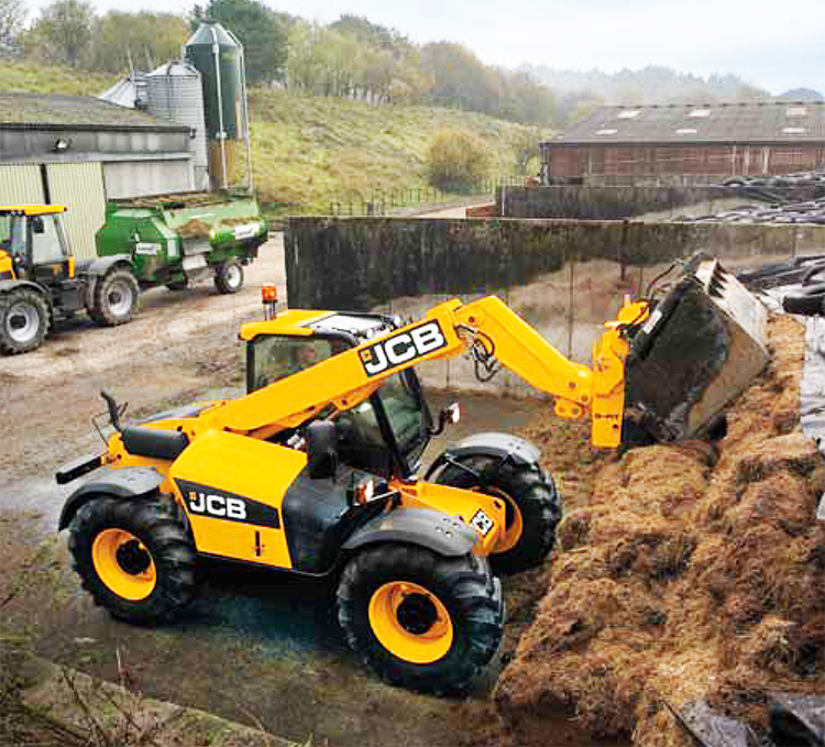 Фото 2. JCB 526-56 Loadall с ковшом-измельчителем слежавшейся силосной массы при загрузке прицепной кормокухни